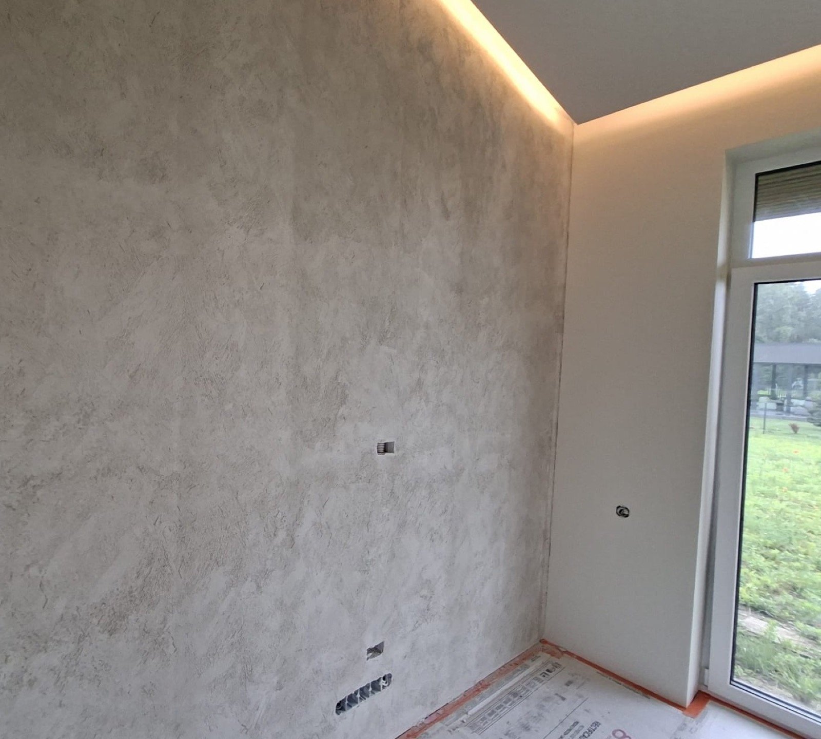 Dekoratyvinio tinko darbai eigoje, kampinė siena su LED apšvietimu